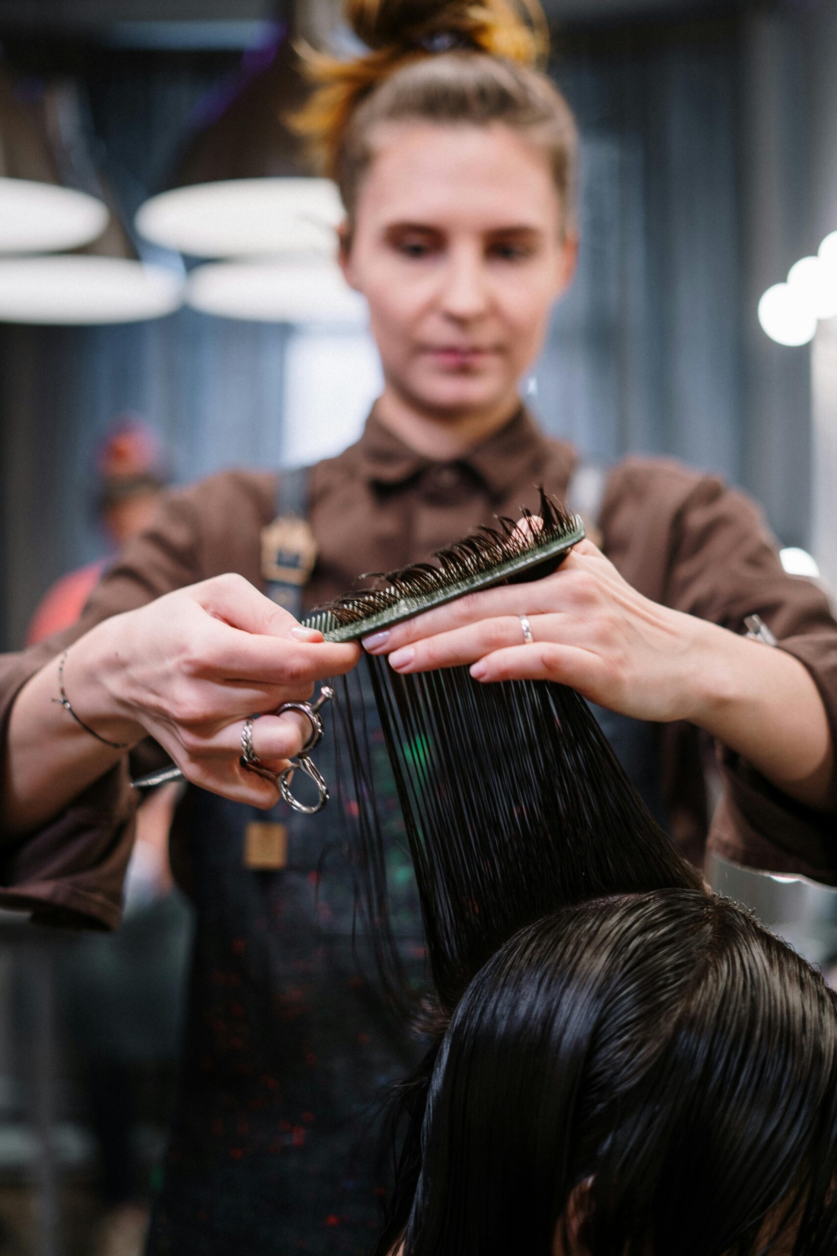 A hairstylist expertly cutting a client's hair in a modern salon setting.